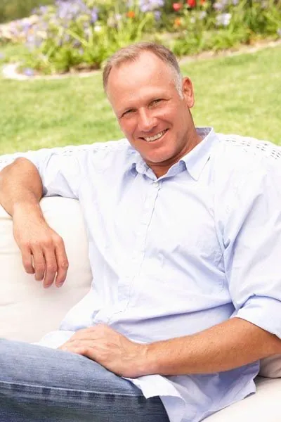 man with dental implants smiling after they helped restore his smile