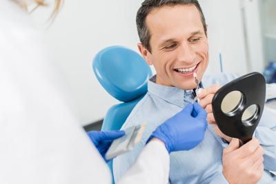 patient picking out what color dental veneers he would like at Lynn Dental Care in Dallas, TX