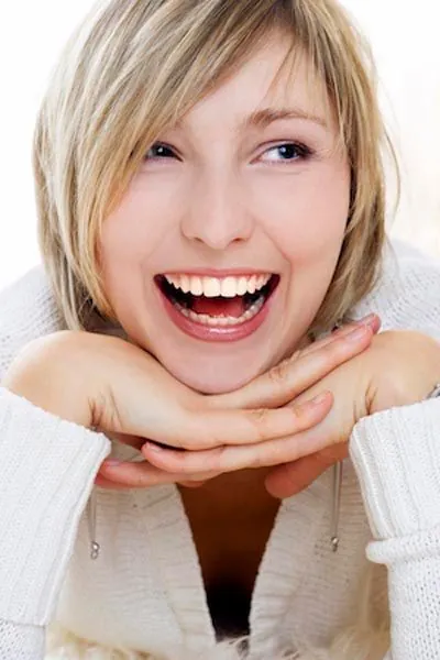 woman showing off her restored smile after getting dental implants