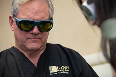 Dr. Brock Lynn wearing protective goggles during a laser dentistry procedure