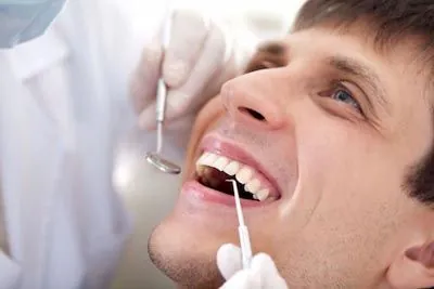 patient getting a dental checkup following an oral surgery procedure at Lynn Dental Care in Dallas, TX