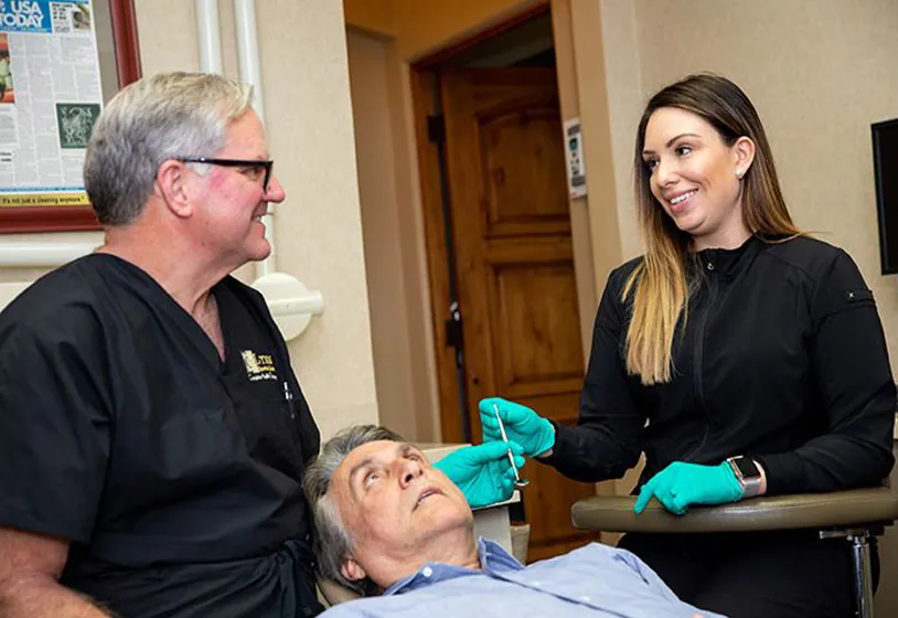 Dallas dentist Dr. Brock Lynn talking with a patient and hygienist at Lynn Dental Care
